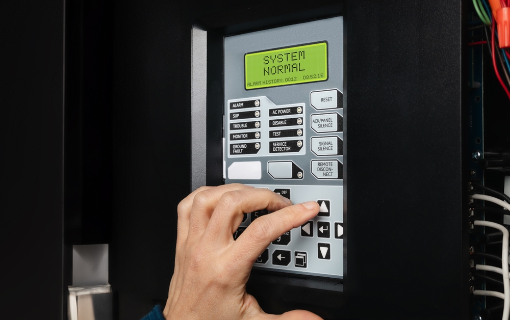 Technician,using,fire,alarm,control,panel,in,service,room.,single Stage