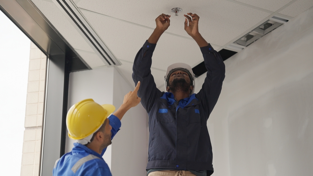 Engineers,team,installing,fire,sprinkler,in,office,at,building,site,